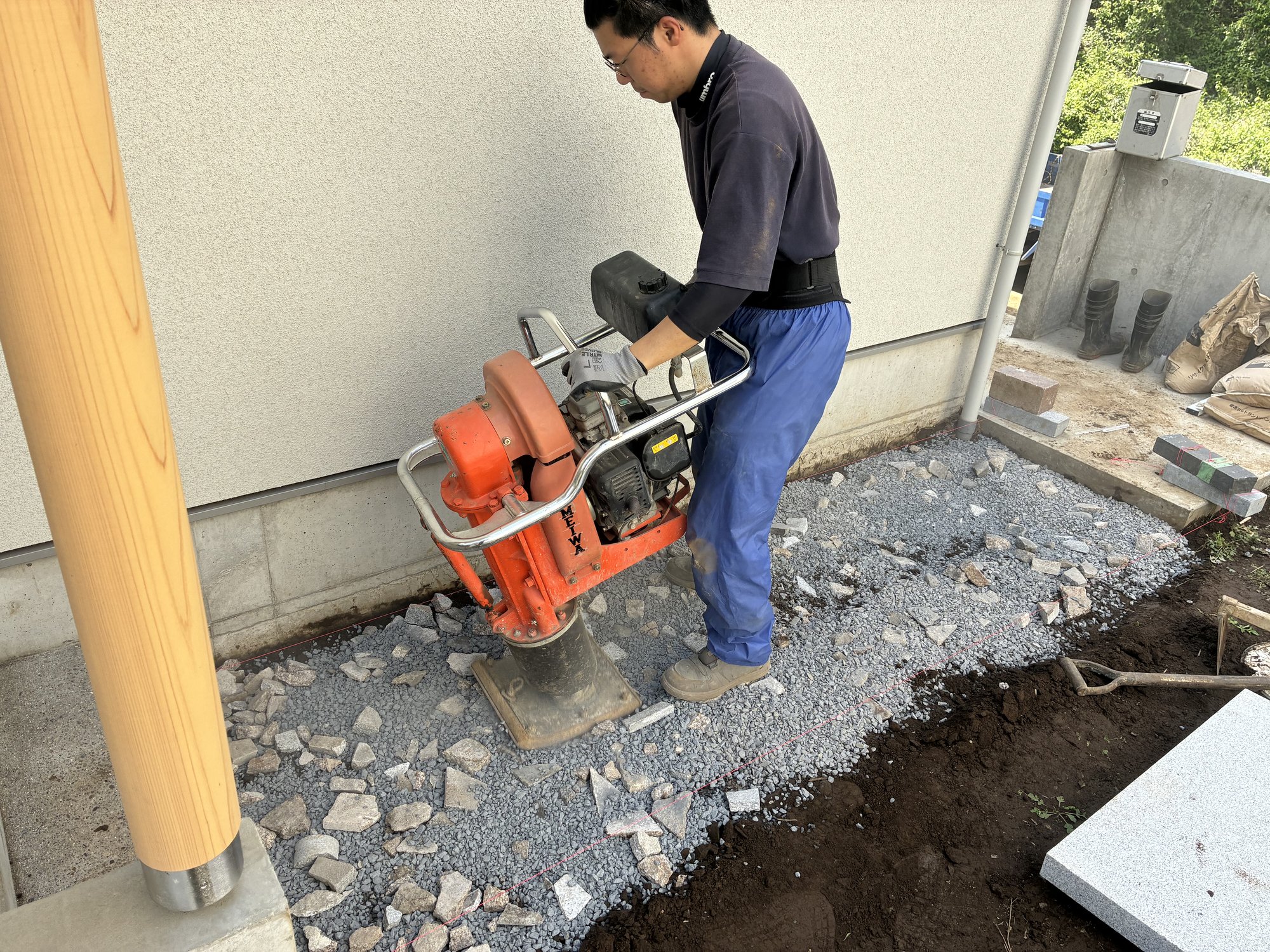 砕石を5cmほど入れてプレートで転圧しているところ。地面をしっかり締め固めます