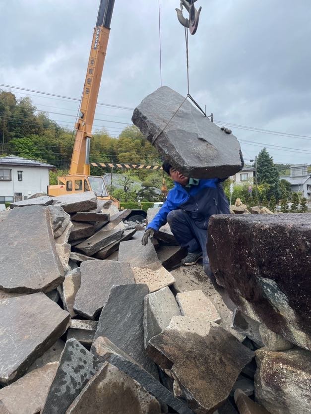 石置き場で、クレーンで起こしながら飛び石を一枚ずつ選んでいるところ