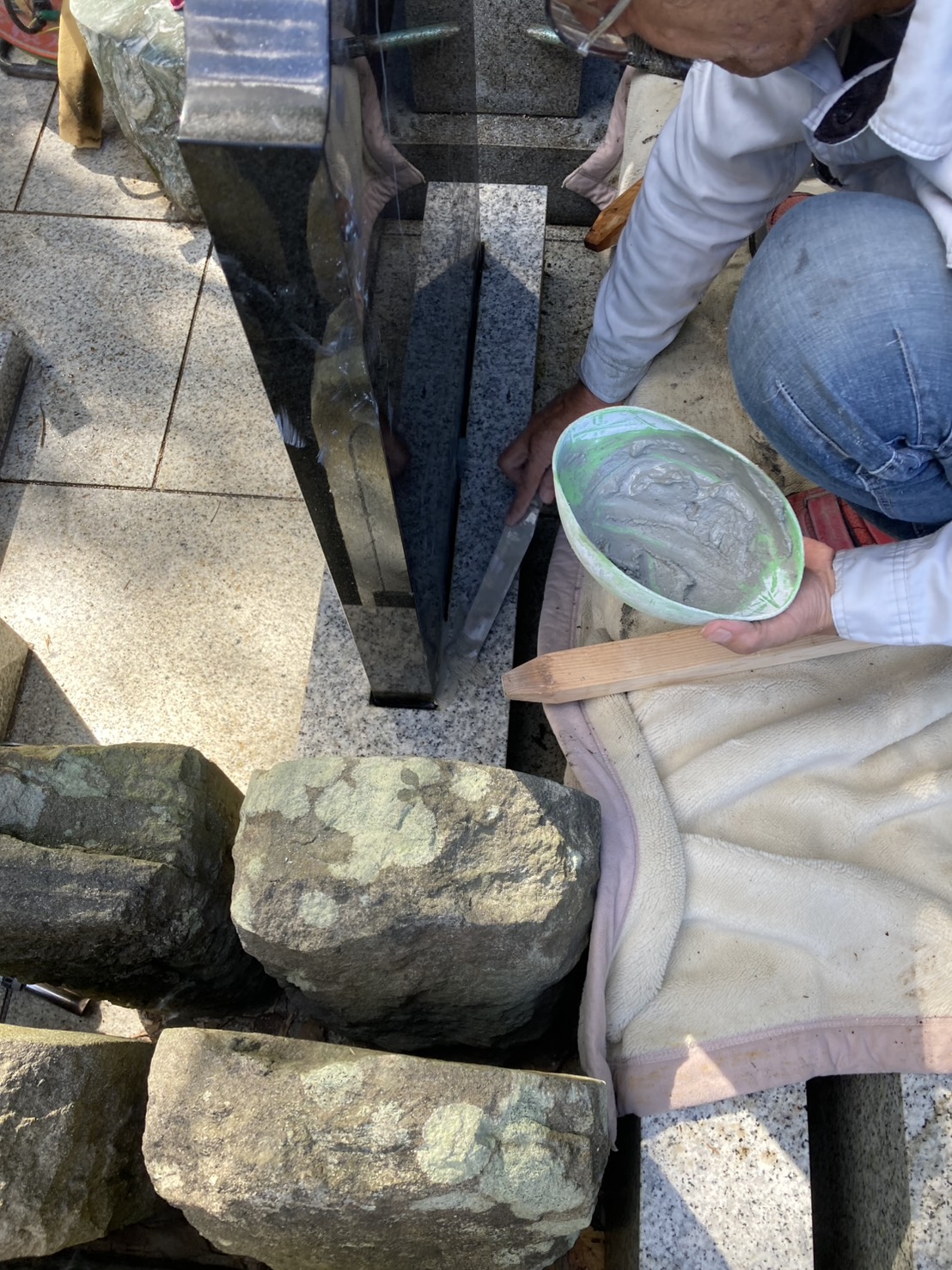 印西市 墓誌の下に水で溶いたセメントを流し込む作業