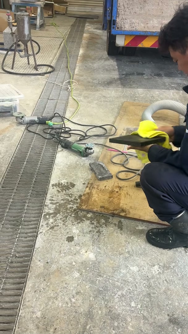 洗い終わった溶岩石プレートを布で拭き上げて仕上げている様子