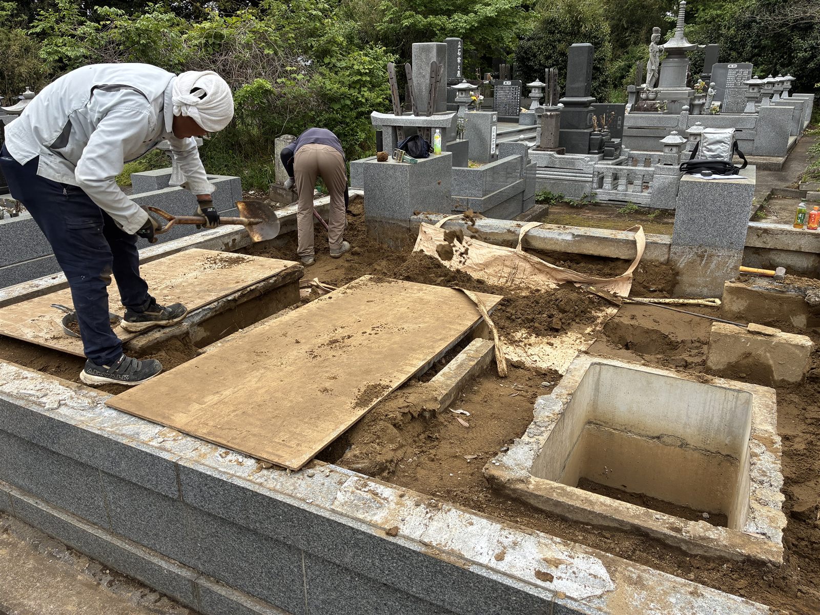 石をどけて、中の土をスコップで出しているところ(八千代市)